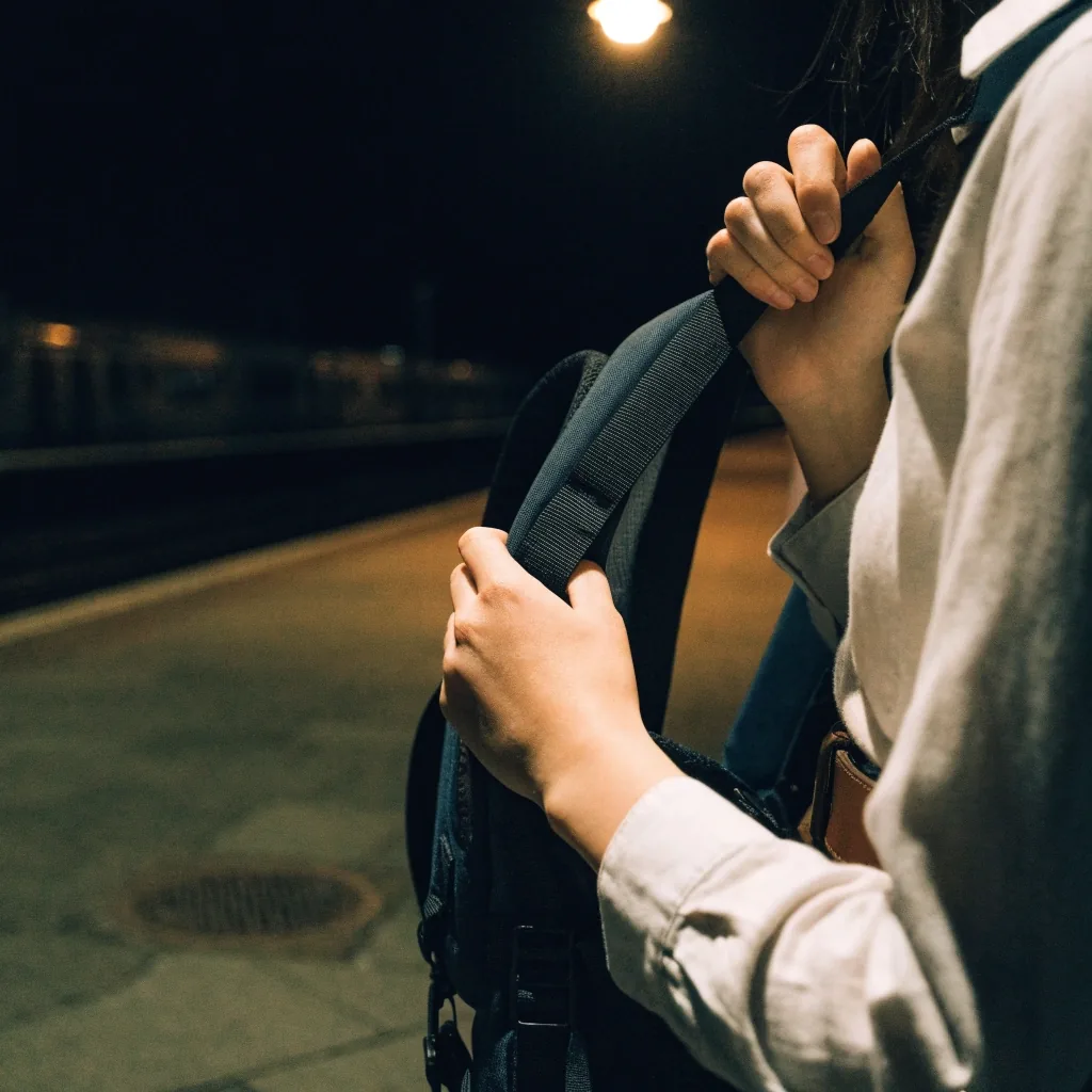 Soft-sided backpack on wet pier boards at night under a single work lamp